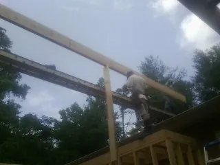 Carpenter setting a ridge beam over a new addition frame — Ice Dam Removal by Roofing Brothers in South Rockwood