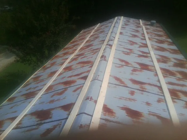 Rusted metal roof panels with new wood purlins before replacement — Storm Damage Roof Repair in South Rockwood by Roofing Brothers