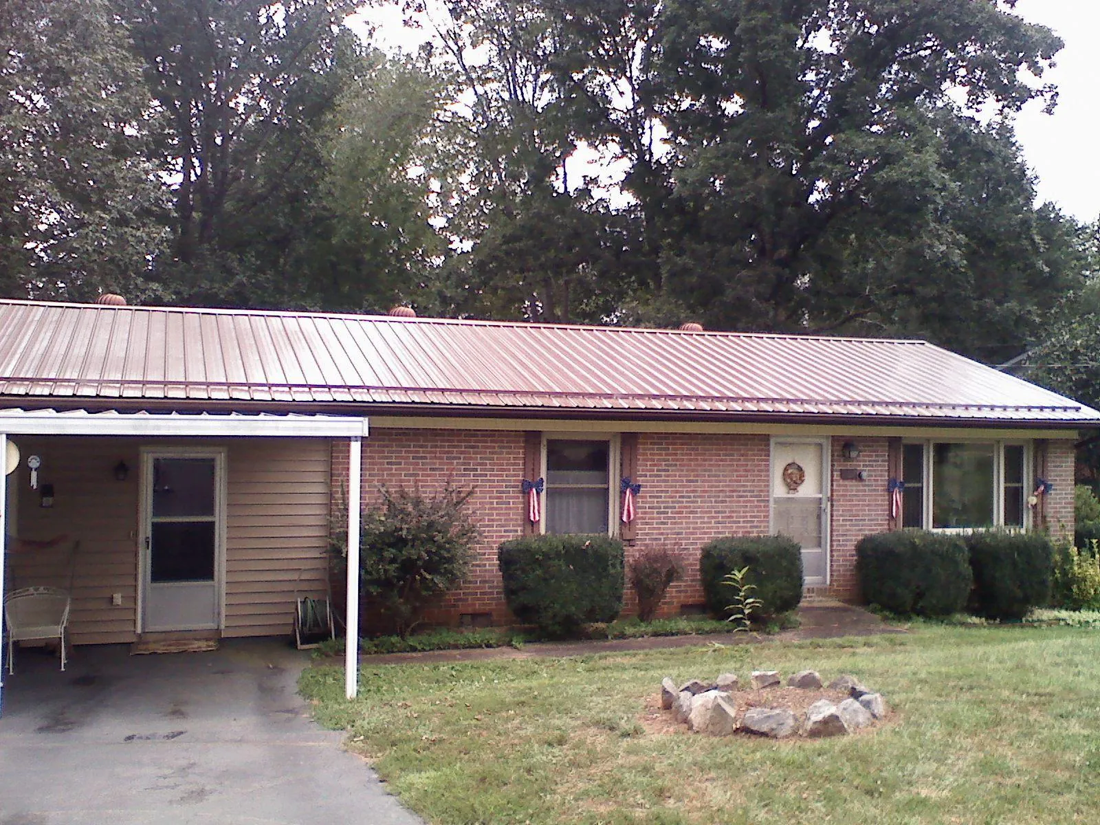 Bronze metal roof and carport on a brick ranch home — Roof Repair work by our crew in South Rockwood